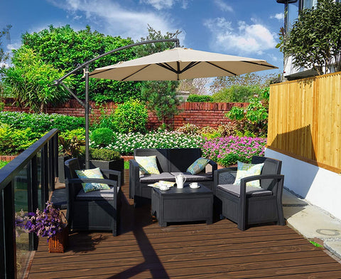 A beige cantilever patio umbrella provides shade over a black outdoor furniture set on a wooden deck. The setting is surrounded by lush greenery, colorful flowers, and a brick wall, creating a cozy outdoor relaxation spot.
Beige Patio Umbrella: Shade for a Lush Outdoor Retreat. Outdoor Offset Umbrella: Enhance Your Garden Seating Area.beige patio umbrella, outdoor umbrella, cantilever umbrella, outdoor seating area, garden shade, wicker furniture.