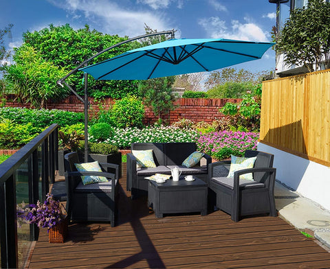 A bright blue cantilever patio umbrella provides shade over a black outdoor furniture set on a wooden deck. The setting is surrounded by lush greenery, colorful flowers, and a brick wall, creating a cozy outdoor relaxation spot.
Blue Patio Umbrella: Shade for a Lush Outdoor Retreat. Outdoor Offset Umbrella: Enhance Your Garden Seating Area.blue patio umbrella, outdoor umbrella, cantilever umbrella, outdoor seating area, garden shade, wicker furniture.