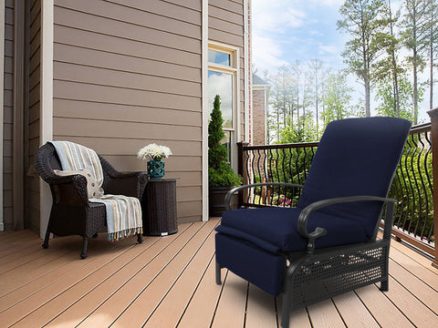 A navy blue-colored outdoor lounge chair with cushioned seating and armrests sits on a wooden deck. Adjacent to it is a wicker chair adorned with a striped throw blanket and a small wicker side table holding a vase of white flowers. The setting includes a house with siding, a railing, and a backdrop of trees.
Navy Blue Outdoor Lounge Chair for Relaxing on the Deck.
navy blue outdoor lounge chair, deck furniture, outdoor relaxation, cushioned seating