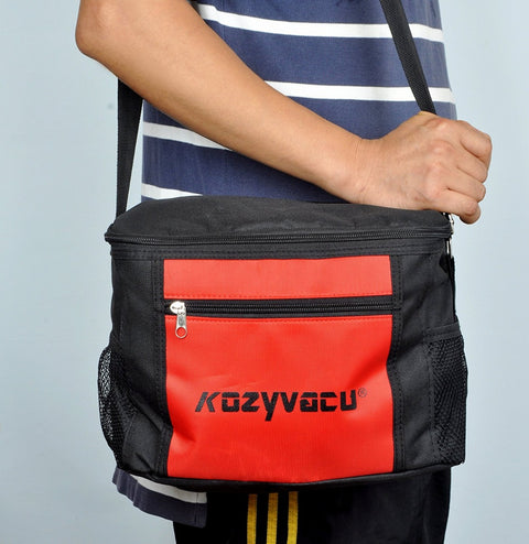 Person carrying a KOZYVACU vacuum pump kit in a black and red bag with shoulder strap.  KOZYVACU vacuum pump, carrying bag, shoulder strap, portable HVAC tool. KOZYVACU Vacuum Pump Kit with Portable Carrying Bag. KOZYVACU vacuum pump, carrying bag, shoulder strap, portable HVAC tool.