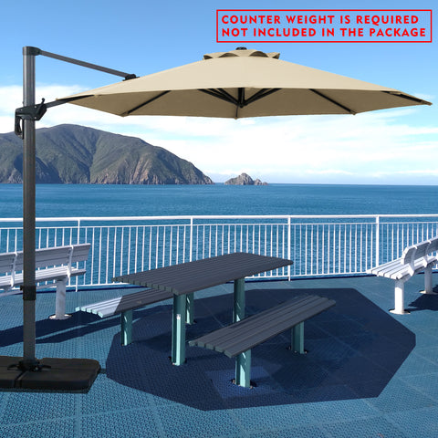 Beige cantilever patio umbrella providing shade over a picnic table by the seaside. Note: Counter weight is required and not included in the package. Outdoor offset umbrella in a coastal setting. It shades an outdoor table, and a counter weight is needed but not part of the package. Seaside Patio Umbrella: Counter Weight Not Included. Cantilever Umbrella for Outdoor Use: Counter Weight Required. cantilever umbrella, patio umbrella, outdoor umbrella, counter weight, umbrella shade