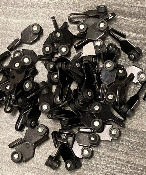A pile of black hooks with wheels and metal parts, likely used for outdoor gazebo curtains or fixtures. These hooks appear to be designed for smooth movement along tracks.A pile of black hooks with wheels and metal parts, likely used for outdoor gazebo curtains or fixtures. These hooks appear to be designed for smooth movement along tracks. A pile of black hooks with wheels and metal parts, likely used for outdoor gazebo curtains or fixtures. These hooks appear to be designed for smooth movement along track