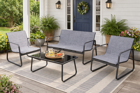 Kozyard Sofia 4-piece outdoor patio furniture set with loveseat, 2 chairs and glass coffee table on a front porch with plants