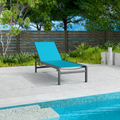 A blue outdoor lounge chair with a sleek black metal frame is positioned beside a swimming pool. The setting includes a wooden fence, green plants, and a concrete patio, creating a serene and relaxing outdoor environment. blue lounge chair, outdoor lounge chair, poolside furniture, black metal frame, relaxation.