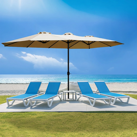 A beige Outdoor Patio Double - Sided Aluminum Umbrella stands on a patio area near a beach. Under the umbrella, there are three blue and white lounge chairs arranged, providing a comfortable spot for relaxation. The backdrop features a clear blue sky, the ocean, and sandy beach, highlighting the umbrella's suitability for outdoor leisure settings.Beige Outdoor Patio Double - Sided Aluminum Umbrella: Beachside Relaxation. beige outdoor umbrella, double - sided aluminum umbrella, patio umbrella, beach lounge.