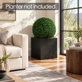 Kozyard faux boxwood topiary ball styled in a square black planter beside a living room window, offering realistic artificial greenery for modern home decor. Dense green foliage creates an elegant indoor plant accent without watering, pruning or maintenance. Ideal for living rooms, entryways, offices, patios and decorative planters. Planter shown in image is not included.