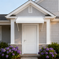 Kozyard white aluminum door awning installed above a front entrance, featuring durable PVC panels and fixed support arms, providing rain, snow, and UV protection for home exterior entryways.