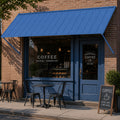 Kozyard 108-inch blue metal door and window awning mounted above a commercial coffee shop entrance, providing durable outdoor shade and rain shelter for storefronts, cafes, and residential entryways with heavy-duty powder-coated iron roof canopy design.
