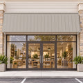 Kozyard 149 inch metal awning installed above a commercial storefront with glass double doors and large display windows, featuring a wide corrugated metal roof panel and wall mounted support brackets. This 12.4 FT outdoor canopy provides extended overhead shade and helps protect business entrances from direct sunlight and rainfall. Ideal for retail storefront awnings, cafe entrances, restaurant door canopies, boutique shops, commercial building facades, and wide exterior doorways.