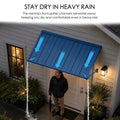 Kozyard blue metal door canopy installed above a front door to stay dry in heavy rain. This waterproof rain shield features built-in front gutter channels that efficiently divert rainwater away to the sides. A man stands safely underneath the shelter during a downpour, demonstrating the commercial-grade weather protection, reliable drainage system, and heavy-duty performance of this outdoor porch awning.