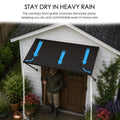 Kozyard exterior door awning highlighting the functional stay dry in heavy rain gutter drainage system channel. The educational graphic shows blue arrows indicating efficient rainwater diversion, routing downpours away from the main front entrance to keep the porch patio walkway completely dry. Perfect for storms, winter blizzards, and rainy seasons, this protective corrugated metal canopy cover shields homeowners, gardeners, and door hardware from water damage and moisture leaks.