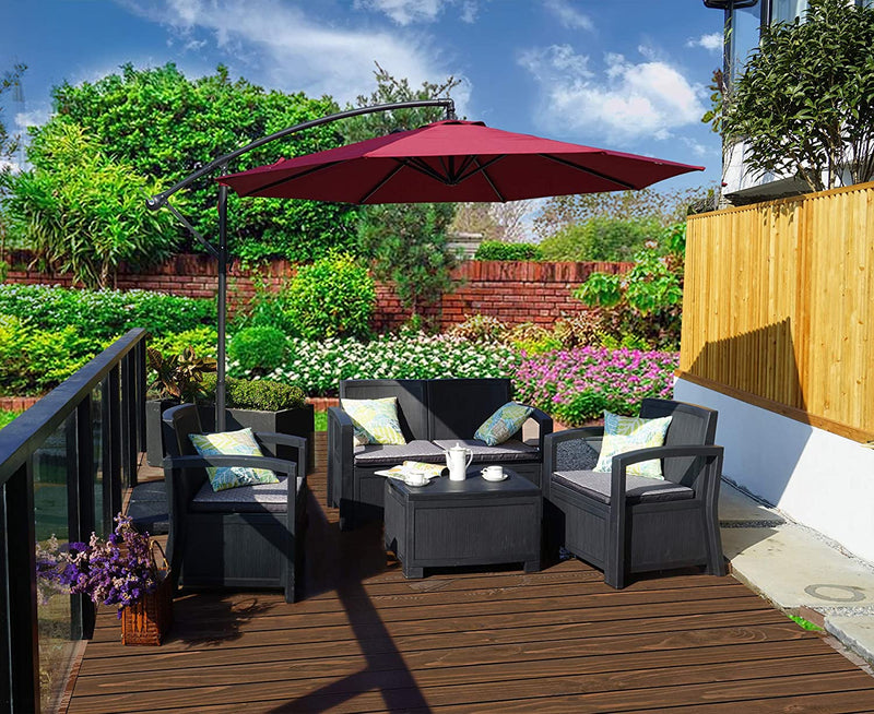 A red cantilever patio umbrella provides shade over a black outdoor furniture set on a wooden deck. The setting is surrounded by lush greenery, colorful flowers, and a brick wall, creating a cozy outdoor relaxation spot.
Red Patio Umbrella: Shade for a Lush Outdoor Retreat. Outdoor Offset Umbrella: Enhance Your Garden Seating Area. red patio umbrella, outdoor umbrella, cantilever umbrella, outdoor seating area, garden shade, wicker furniture.