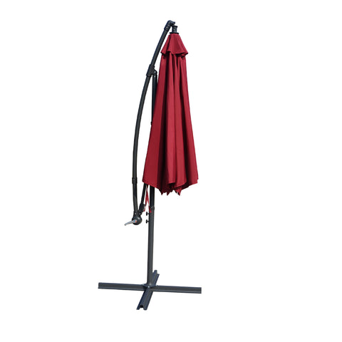 Side - view image of a collapsed red outdoor offset umbrella supported by a black frame and base. The umbrella is bundled up, indicating it is ready for storage or transport. Folded Red Cantilever Patio Umbrella: Compact and Ready for Storage. Collapsed Red Outdoor Umbrella: Space - Saving Design. red patio umbrella, cantilever umbrella, folded umbrella, outdoor umbrella, compact umbrella, umbrella storage
