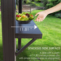 A close - up image of a dark - colored side shelf on an outdoor iron barbecue pavilion. A hand is reaching towards a bowl of salad placed on the shelf. The width of the shelf is marked as 11.81 inches, and the text below highlights that the spacious desk surface offers ample area for placing items. Spacious Side Shelf on Outdoor Iron Barbecue Pavilion. outdoor iron barbecue pavilion, side shelf, spacious desk surface, 11.81 - inch width, item placement.