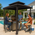 Kozyard backyard grill gazebo at night illuminated with warm hanging string lights for an outdoor family dinner party. Features a happy chef grilling at the BBQ station while friends and family dine under the illuminated hardtop shelter. Creates a cozy, welcoming ambiance for evening patio barbecues, nighttime backyard social gatherings, and holiday cooking events. Perfect premium metal roof pavilion designed for memorable twilight dining experiences.