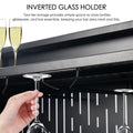 A close - up of a black bar table featuring an inverted glass holder. A hand is seen placing a wine glass on the holder, with additional glasses stored upside - down. The design offers convenient storage for glassware, keeping the bar area organized. Black Bar Table with Inverted Glass Holder. Bar table, inverted glass holder, glassware storage.