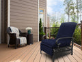 A navy blue-colored outdoor lounge chair with cushioned seating and armrests sits on a wooden deck. Adjacent to it is a wicker chair adorned with a striped throw blanket and a small wicker side table holding a vase of white flowers. The setting includes a house with siding, a railing, and a backdrop of trees.
Navy Blue Outdoor Lounge Chair for Relaxing on the Deck.
navy blue outdoor lounge chair, deck furniture, outdoor relaxation, cushioned seating