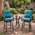 Kozyard swivel bar stools with cushions arranged around a matching small round bistro table with drinks on a paved stone patio backyard setup illuminated by warm outdoor string lights.