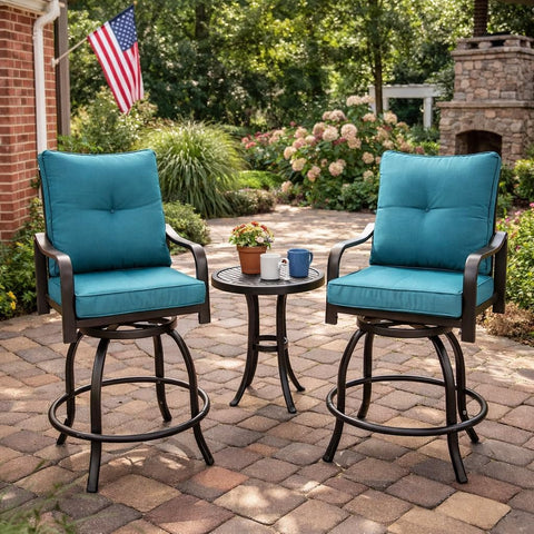Kozyard swivel bar stools with cushions arranged around a matching small round bistro table with drinks on a paved stone patio backyard setup illuminated by warm outdoor string lights.