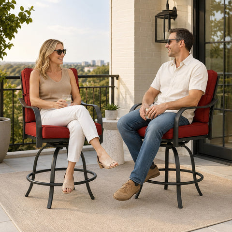 Kozyard modern outdoor swivel bar stools with armrests being enjoyed by a man and woman drinking wine and relaxing on a stylish apartment balcony overlooking urban residential buildings.