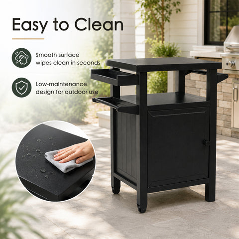 Kozyard easy-to-clean outdoor kitchen prep cart featuring a low-maintenance design for all-weather outdoor use. A hand wipes water droplets off the smooth, dark gray powder-coated metal surface using a gray microfiber cloth. This highlights the rust-resistant, waterproof, and oil-proof properties of the tabletop, making post-grill cleanup quick and effortless for backyard BBQ enthusiasts.