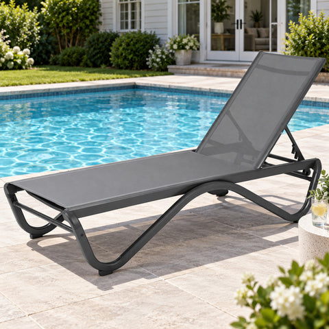 Kozyard outdoor chaise lounge chair beside a swimming pool, designed for comfortable sunbathing and relaxing outdoor living. This adjustable patio recliner features breathable mesh fabric, supportive ergonomic seating, multiple backrest positions and a durable weather-resistant frame, making it ideal as a pool lounge chair, patio sun lounger, deck chair, backyard recliner or garden lounge furniture.