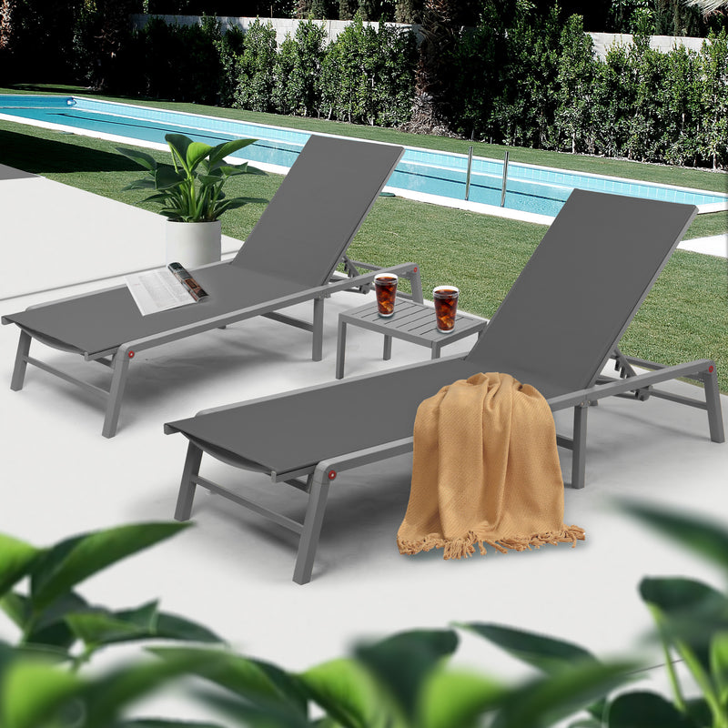 Elegant Gray Poolside Lounge Chair Set
alt text：A set of gray lounge chairs by the pool, accessorized with a magazine, drinks, and a beige throw blanket, set against a backdrop of greenery and a pool. Keywords: gray lounge chairs, poolside, outdoor relaxation
