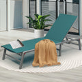 Cozy Teal Outdoor Lounge Chair
alt text：A teal outdoor lounge chair adorned with a beige throw blanket and a magazine, placed on a patterned rug next to a potted plant, perfect for patio relaxation. Keywords: teal lounge chair, outdoor relaxation, patio decor