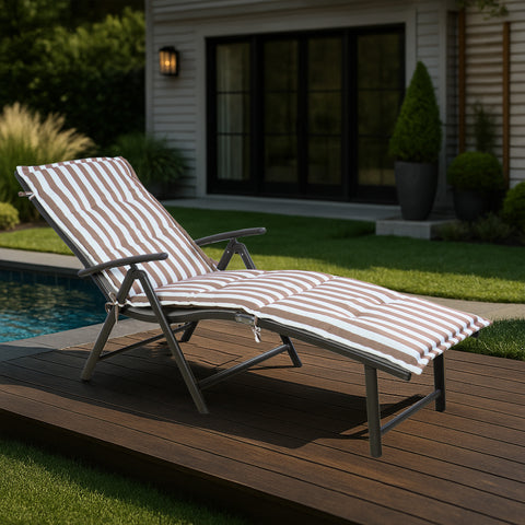 A foldable lounge chair with striking blue and white striped cushions is placed beside a pool, overlooking the sea. The chair comes with a convenient side cup - holder, perfect for relaxing by the water.Foldable Lounge Chair with Blue - White Striped Cushions by the Poolside. foldable lounge chair, blue and white striped cushions, poolside chair, side cup - holder, seaside relaxation.