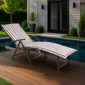 A foldable lounge chair with striking blue and white striped cushions is placed beside a pool, overlooking the sea. The chair comes with a convenient side cup - holder, perfect for relaxing by the water.Foldable Lounge Chair with Blue - White Striped Cushions by the Poolside. foldable lounge chair, blue and white striped cushions, poolside chair, side cup - holder, seaside relaxation.