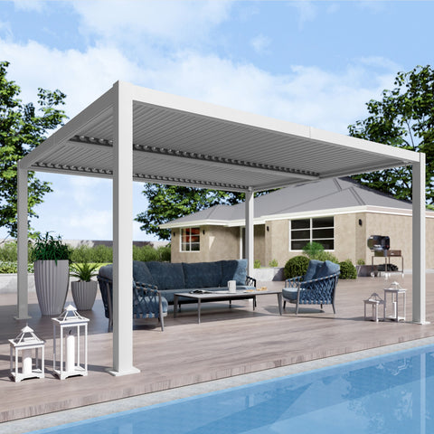 A modern white louvered pergola offers shade over a stylish outdoor lounge area by a pool. The space features a dark blue sofa set, a coffee table, decorative lanterns, and potted plants, creating a serene and inviting outdoor living environment. White Louvered Pergola for Poolside Lounge. louvered pergola, poolside, outdoor lounge, white pergola, outdoor living.
