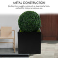 A black cube - shaped metal planter with a sleek matte finish, crafted from quality steel. It holds a lush, spherical green plant, suitable for both indoor and outdoor use, enhancing any space with its modern design. Black Cube Metal Planter - Quality Steel Construction. cube metal planter, steel planter box, black steel flower pot, metal construction.