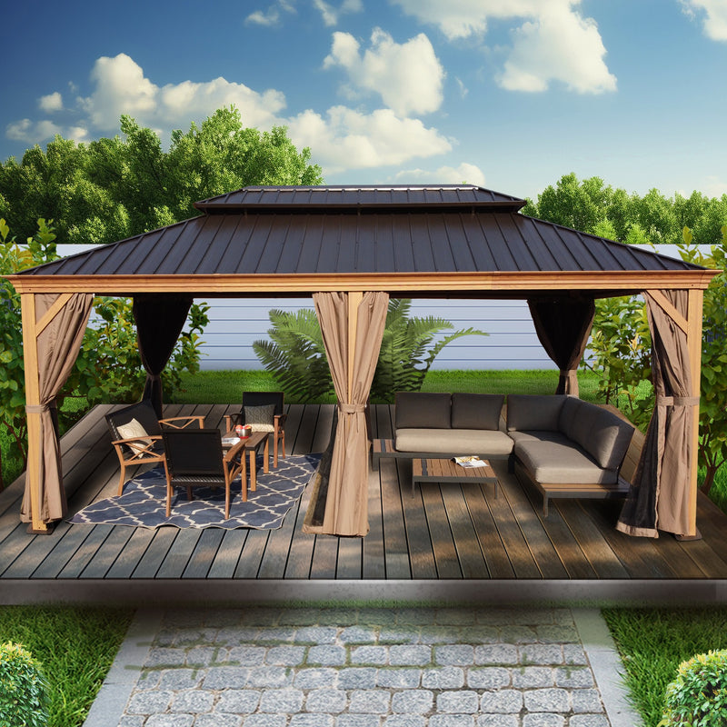 An inviting outdoor aluminum gazebo with a wood - grain finish, featuring a dark metal roof. The gazebo is set on a wooden deck, surrounded by lush greenery. Inside, there is a comfortable seating area with a modern sectional sofa, a coffee table, and a small dining setup with chairs. Beige curtains add a touch of elegance to the space. Charming Outdoor Aluminum Wood - Grain Gazebo for Relaxation. outdoor aluminum gazebo, wood - grain finish, dark metal roof, seating area, beige curtains.