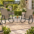 Kozyard outdoor rocking chair shown in a stylish garden patio setting with white aluminum frame, gray Textilene fabric and modern curved rocker base. This weather-resistant patio rocking chair is ideal for porch, backyard, balcony, deck, garden and poolside relaxation, offering breathable seating, lightweight construction and comfortable outdoor lounge furniture style.