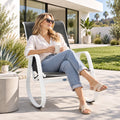 Kozyard outdoor rocking chair with white aluminum frame and gray breathable Textilene seat shown in a modern backyard patio setting. Comfortable high-back patio rocker offers smooth rocking motion, weather-resistant outdoor durability and lightweight construction, creating relaxing seating for porch, deck, balcony, garden, backyard and poolside outdoor living spaces.