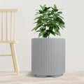 A sleek gray plastic planter pot with vertical ribbed texture holds a lush green plant. The planter is placed on a light - toned wooden floor next to a simple, light - colored wooden chair, set against a plain white background. The combination of the modern - looking pot and the natural greenery creates a stylish and minimalist indoor scene. Modern Gray Plastic Planter Pot: Stylish Indoor Greenery.gray plastic planter, ribbed planter pot, indoor plant pot, modern planter, minimalist planter.