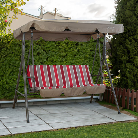 A Kozyard outdoor swing chair situated on a paved patio area, surrounded by lush greenery. The swing features a sturdy metal frame and a canopy in a muted brown color. The seat is adorned with a cushion that has a vibrant pattern of red, grey, and white vertical stripes, adding a pop of color to the outdoor setting. Kozyard Outdoor Swing Chair: Relax in Style in Your Garden. Kozyard swing chair, outdoor patio swing, striped - cushion swing, swing with canopy, garden swing chair.