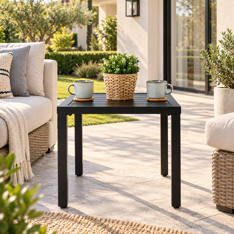 Kozyard black outdoor side table for patio, balcony, porch and garden seating areas, featuring a compact square slatted metal tabletop, sturdy four-leg construction and modern minimalist design. This weather-resistant patio end table is ideal beside outdoor sofas and chairs for holding coffee, drinks, plants, books and décor in small outdoor spaces.