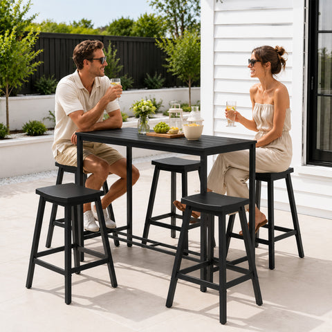 Kozyard Outdoor Bistro Set in use by a happy couple enjoying drinks and talking on a sunny backyard patio. Modern black metal bar table with 4 stools, creating a cozy and stylish outdoor lounge area for everyday dining and social gatherings.