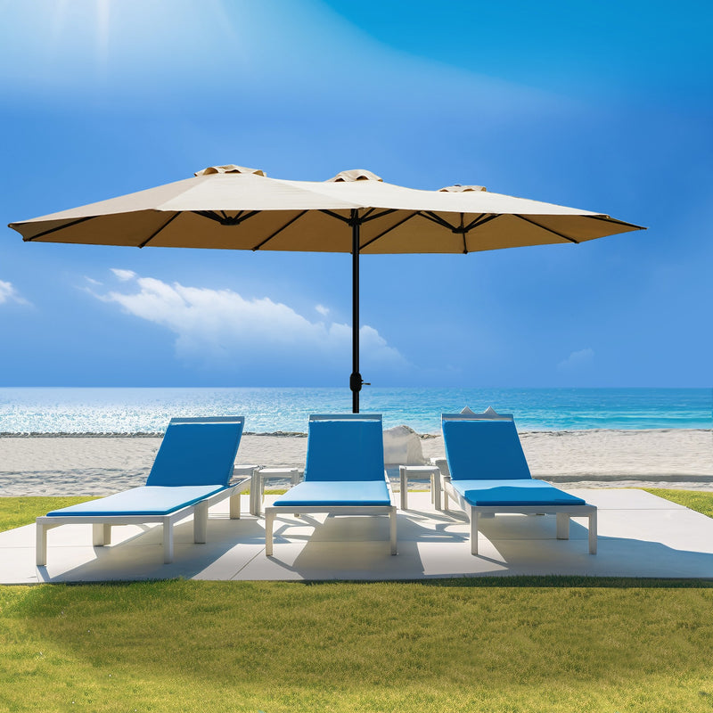 A beige Outdoor Patio Double - Sided Aluminum Umbrella stands on a patio area near a beach. Under the umbrella, there are three blue and white lounge chairs arranged, providing a comfortable spot for relaxation. The backdrop features a clear blue sky, the ocean, and sandy beach, highlighting the umbrella's suitability for outdoor leisure settings.Beige Outdoor Patio Double - Sided Aluminum Umbrella: Beachside Relaxation. beige outdoor umbrella, double - sided aluminum umbrella, patio umbrella, beach lounge.