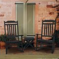 Black Wooden Rocking Chair Set for Outdoor Relaxation
A set of two black wooden rocking chairs and a small side table, positioned on a wooden porch in front of a stone wall with green shutters. Ideal for creating a cozy outdoor spot for relaxation and conversation.