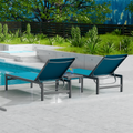 Two blue outdoor lounge chairs with dark metal frames are placed beside a swimming pool. The surrounding area features lush greenery and a wooden fence, creating a serene and inviting outdoor relaxation space. blue outdoor lounge chairs, poolside loungers, outdoor relaxation furniture, dark-framed lounge chairs.