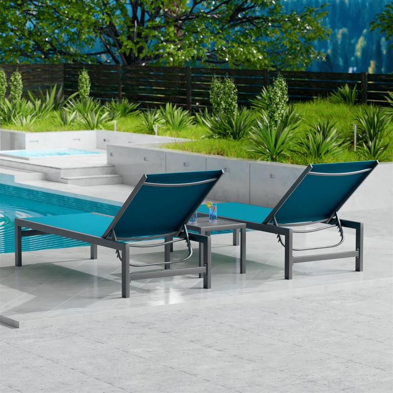 Two blue outdoor lounge chairs with dark metal frames are placed beside a swimming pool. The surrounding area features lush greenery and a wooden fence, creating a serene and inviting outdoor relaxation space. blue outdoor lounge chairs, poolside loungers, outdoor relaxation furniture, dark-framed lounge chairs.