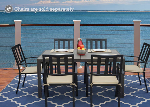An outdoor dining scene featuring a rectangular composite wood dining table with a white frame, set against a stunning ocean view. The table is accompanied by black chairs with beige cushions, and there are place settings, a bowl of fruit, and a red pitcher on the table. Note: Chairs are sold separately. Rectangular Outdoor Dining Table with Ocean View (Chairs Sold Separately). rectangular outdoor dining table, composite wood table, white - framed table, outdoor chairs, ocean view dining