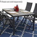 An outdoor dining setup with a rectangular composite wood dining table. The table is set with plates, napkins, a bowl of fruit, and a red carafe. Surrounding the table are six dark - colored folding chairs with fabric seats. Note: Chairs are sold separately. The table and chairs are placed on a blue patterned rug. Rectangular Outdoor Dining Table with Chairs (Sold Separately)rectangular dining table, composite wood table, outdoor dining set, folding chairs, sold separately.