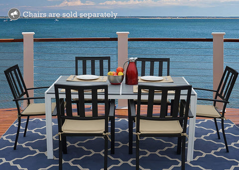 An outdoor dining scene featuring a rectangular composite wood dining table with a white frame, set against a stunning ocean view. The table is accompanied by black chairs with beige cushions, and there are place settings, a bowl of fruit, and a red pitcher on the table. Note: Chairs are sold separately. Rectangular Outdoor Dining Table with Ocean View (Chairs Sold Separately). rectangular outdoor dining table, composite wood table, white - framed table, outdoor chairs, ocean view dining