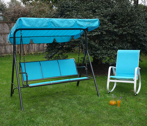 A blue-colored outdoor swing chair with a matching canopy is set on a lush green lawn, accompanied by a gray-hued rocking chair with patterned cushions. The swing chair, featuring the brand "Kozyard," provides a cozy spot for relaxation in a garden setting, surrounded by greenery and a wooden fence in the background. Blue Kozyard Swing Chair: A Relaxing Outdoor Retreat.blue swing chair, Kozyard swing, outdoor seating, garden swing, rocking chair