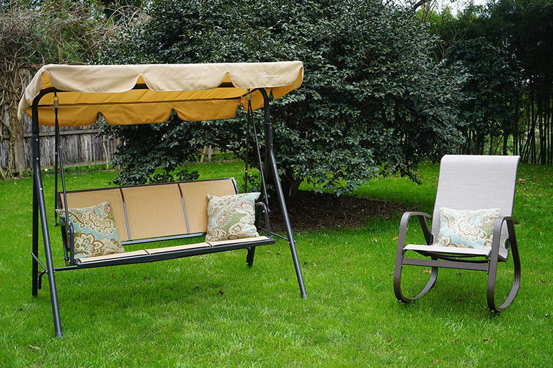 A beige - colored outdoor swing chair with a matching canopy is set on a lush green lawn, accompanied by a gray - hued rocking chair with patterned cushions. The swing chair, featuring the brand "Kozyard," provides a cozy spot for relaxation in a garden setting, surrounded by greenery and a wooden fence in the background.Beige Kozyard Swing Chair: A Relaxing Outdoor Retreat.beige swing chair, Kozyard swing, outdoor seating, garden swing, rocking chair