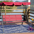 A red-colored outdoor swing chair with a canopy is placed on a wooden deck by the water. The swing has a sturdy black metal frame and is positioned on a blue patterned rug. Next to the swing, there is a small black metal table with two glasses of orange beverages and a bunch of purple flowers. A potted plant adds a touch of greenery to the scene. Red Swing Chair by the Water: A Serene Outdoor Retreat.
Keywords: red swing chair, outdoor swing, swing with canopy, waterfront seating, patio furniture