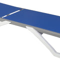 A modern outdoor lounge bed with a sleek design. It has a flat, blue - colored surface and is supported by a white, angular frame. The adjustable backrest mechanism is visible at the rear. Sleek Modern Outdoor Lounge Bed. outdoor lounge bed, modern design, adjustable backrest, blue surface, white frame.